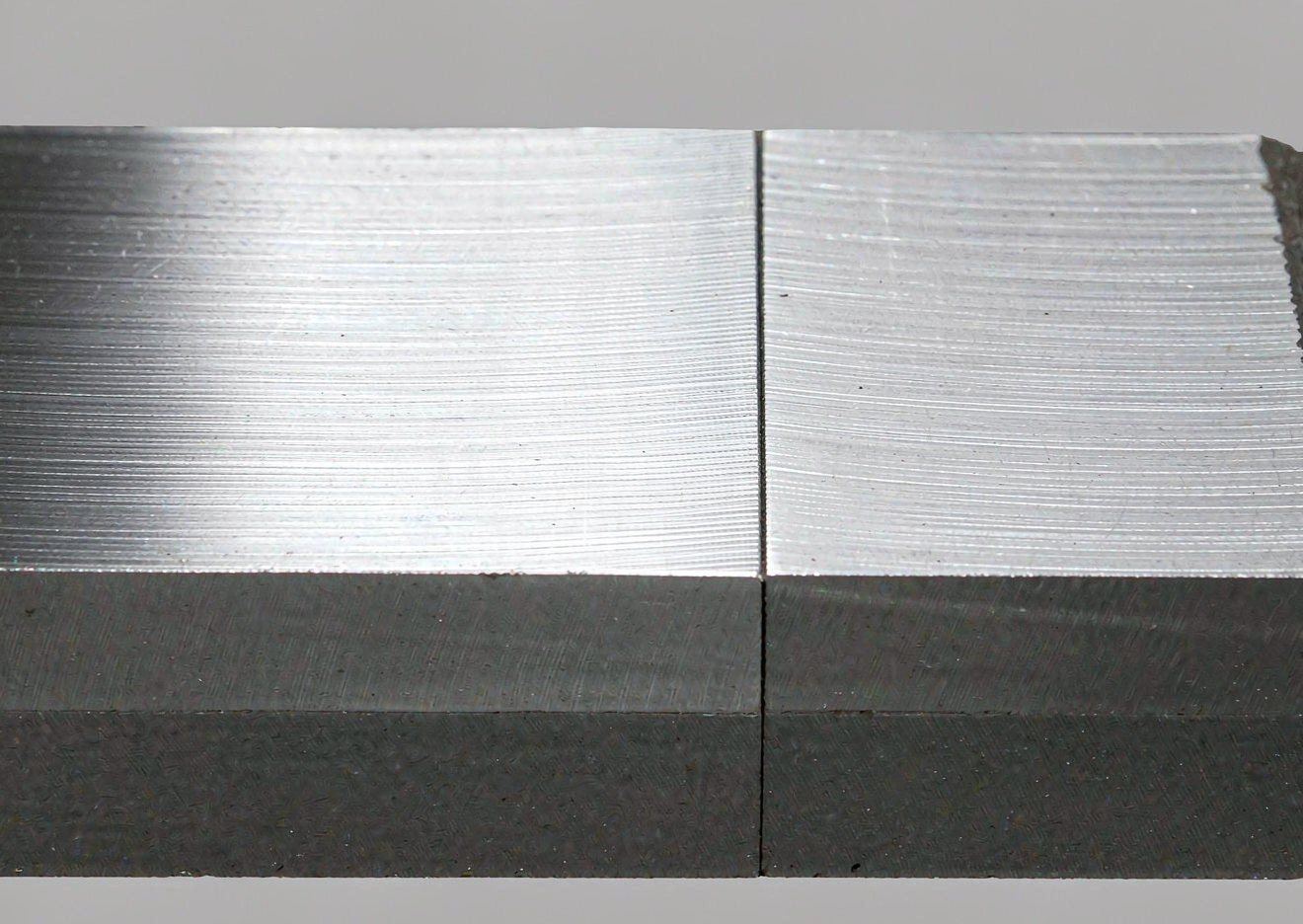 Macro close-up of a clad plate cut edge showing the stainless layer bonded to the carbon steel base