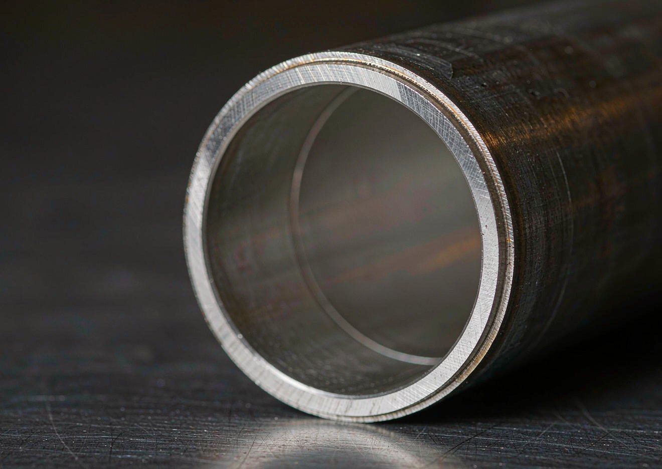 Machined end face of stainless steel clad pipe, the bright alloy bore fused to the dark carbon steel base pipe wall