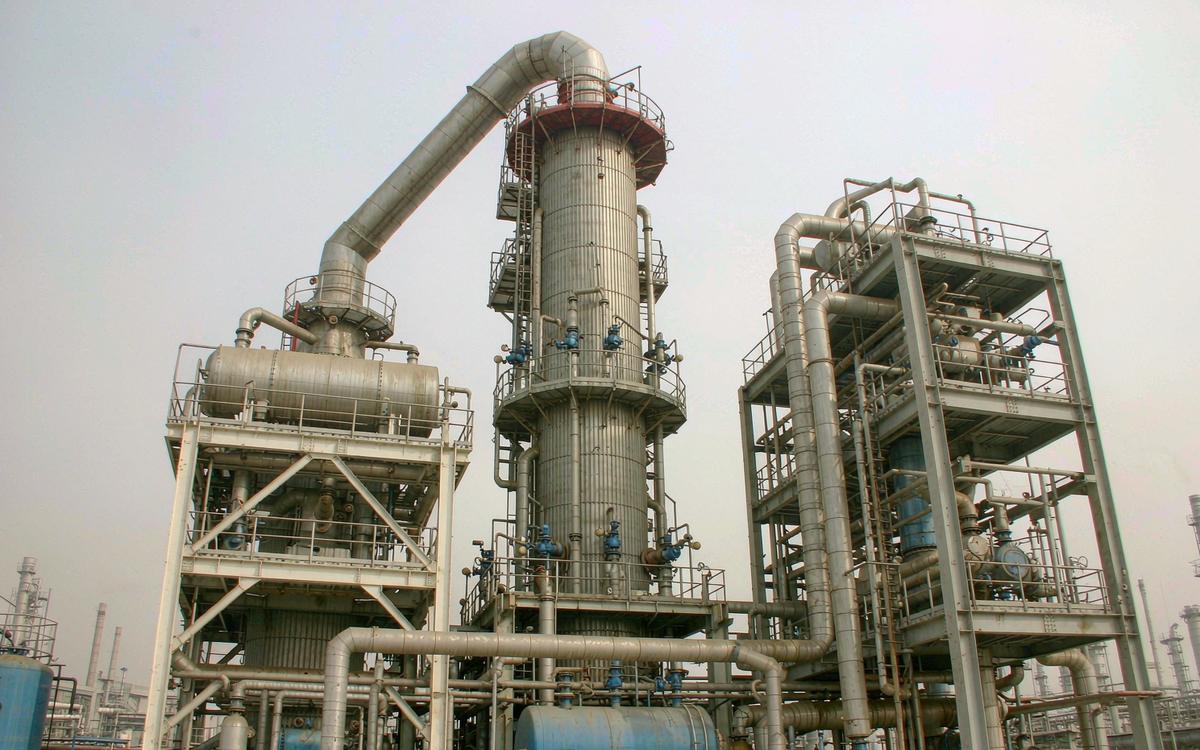 Refinery vacuum distillation tower with overhead vapour duct and condensers